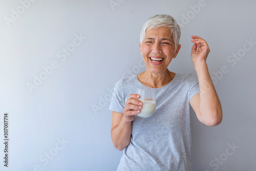Papier peint Cheerful mature woman having fun while drinking milk