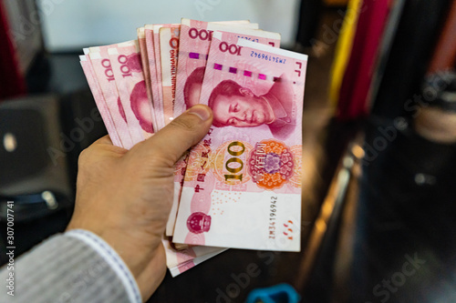 Chinese money, RMB, close up shot of hand holding bunch of yuan value of China