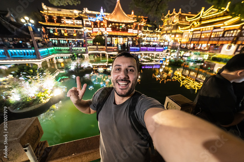 Happy tourist man take selfie with Shanghai skyline, handsome similing man traveling in China