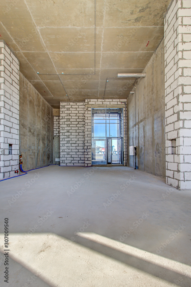Monolithic brick basement wall. heating pipes lie on floor. New empty