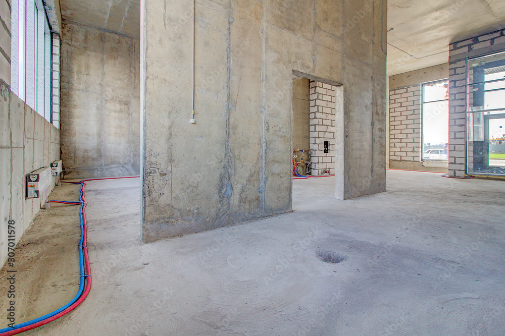 Monolithic brick basement wall. heating pipes lie on floor. New empty