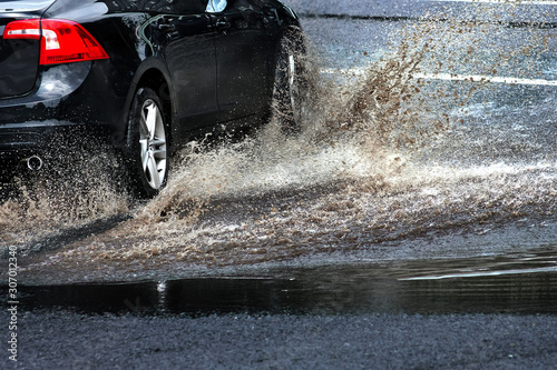 Car and water splash after rain on road