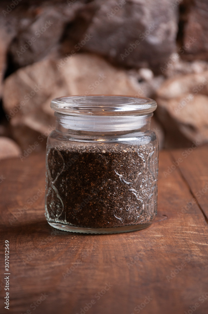 Chia jar on the rustic table with stone background. Vertical with copyspace. Chia jar on the rustic table with stone background. Vertical with copyspace.