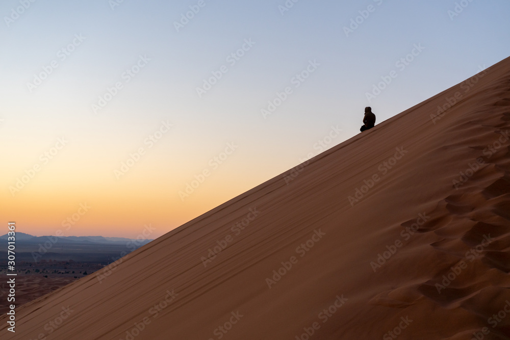 Man on the slope of Sand dune of Erg Chebbi in the Sahara Desert, Morocco Man on the slope of Sand dune of Erg Chebbi in the Sahara Desert, Morocco