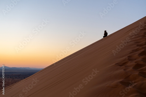 Man on the slope of Sand dune of Erg Chebbi in the Sahara Desert, Morocco