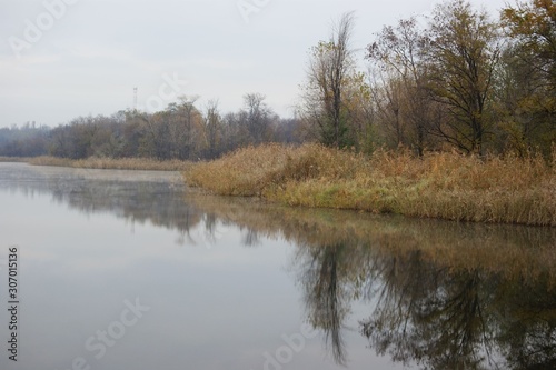 Landscape view of a lake with pipes of a large plant in the background