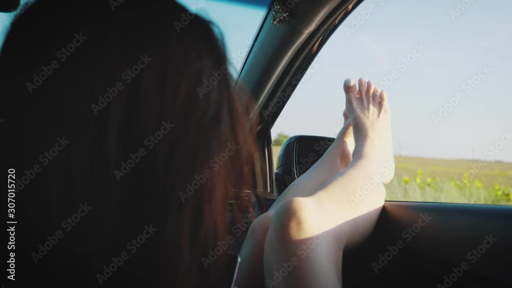custom made wallpaper toronto digitalA girl by sticking out her legs in an open window car. Young woman likes to travel by car, travel concept, lifestyle.