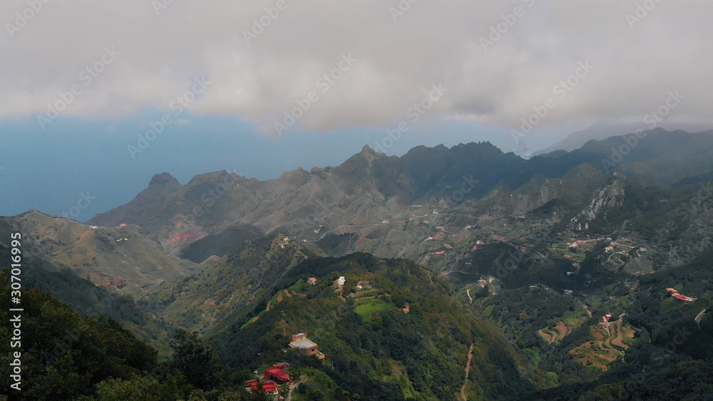 Strong wind high in the mountains, aerial view of the valley and small villages in the mountain range