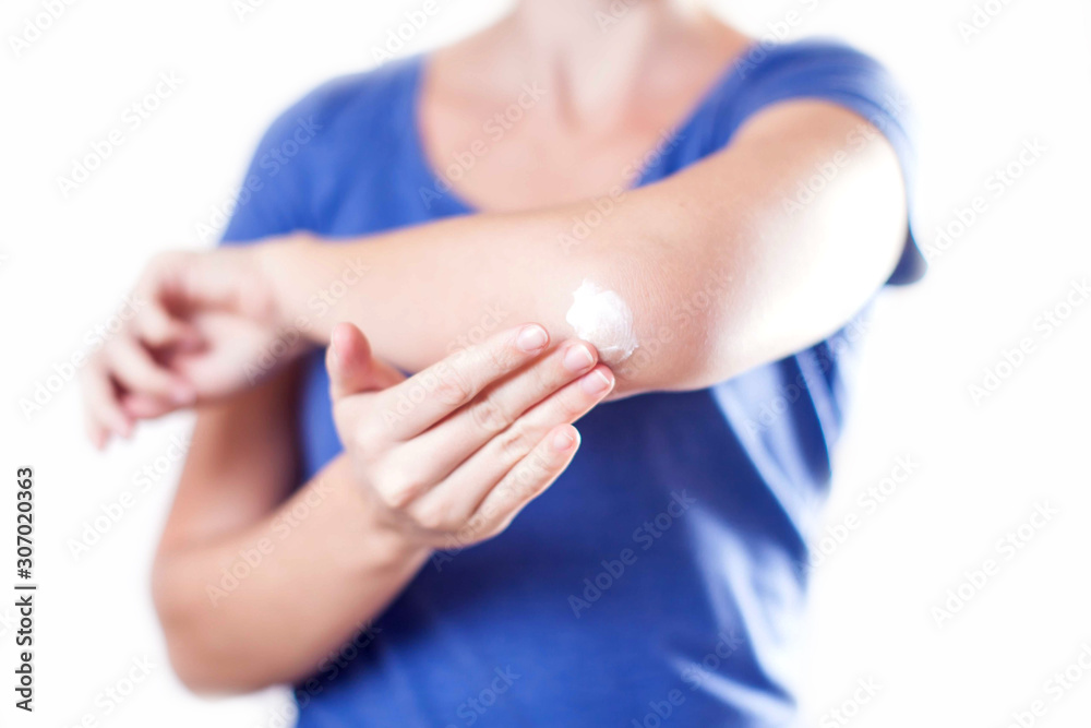 Woman applies cream on her elbow isolated. People, healthcare and medicine concept