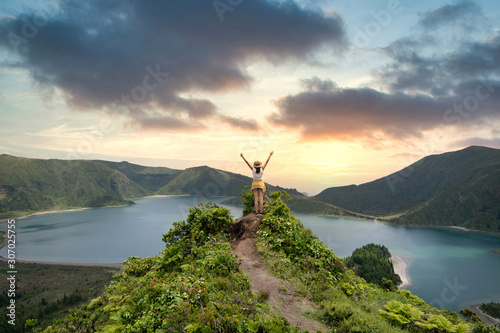 woman traveler holding hat and looking at amazing mountains and forest, wanderlust travel concept, space for text, atmospheric epic moment, azores ,portuhal, ponta delgada, sao miguel photo