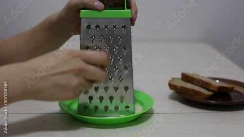 Hands grating cheese. Close-up footage.