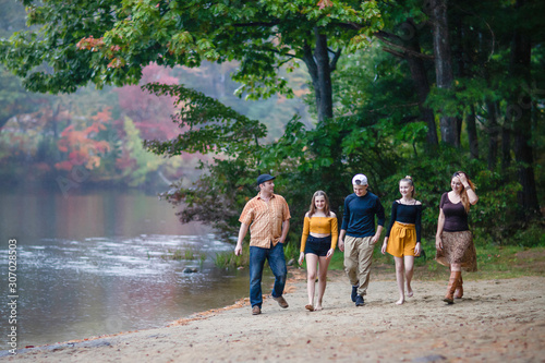 white Caucasian family walking by the lake on fall. teenagers and parents. 
