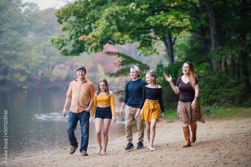 white Caucasian family walking by the lake on fall. teenagers and parents. 