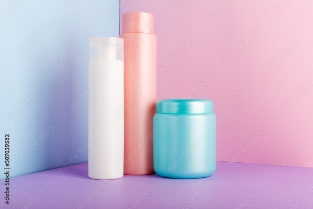 Set of cosmetic products on pink background. Cosmetic package collection for shampoo, mask, conditioner, shower gel. Pink, white, blue plastic bottles, jar for packaging cosmetics Mock up, copy space Set of cosmetic products on pink background. Cosmetic package collection for shampoo, mask, conditioner, shower gel. Pink, white, blue plastic bottles, jar for packaging cosmetics Mock up, copy space