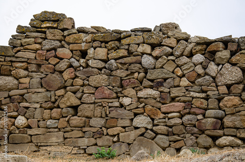 The wall of the old fortress, made of stone. Background from an old stone.