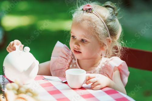 Little girl having a tea party in the backyard photo