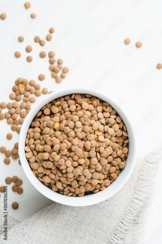 Dried green lentils on a white plaster textured background