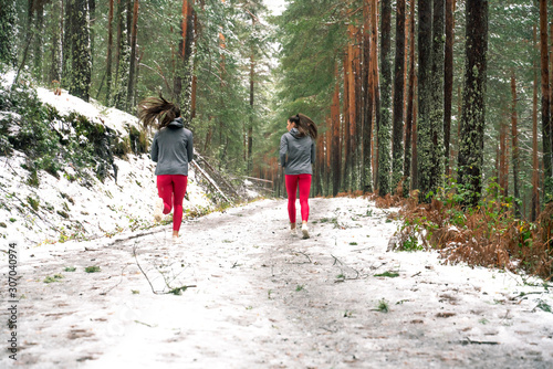 twins running through the snowy forest