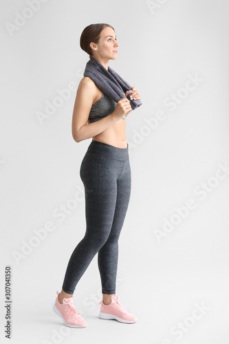 Sporty young woman on light...