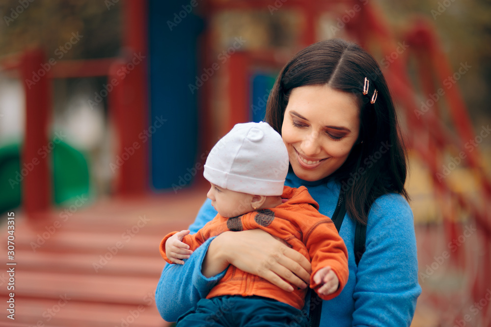 Mother Holding her Baby Outdoors in a Playground Mother Holding her Baby Outdoors in a Playground