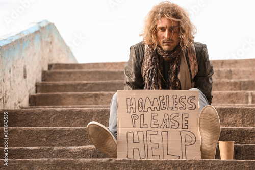 Obraz na plátne Portrait of poor homeless man sitting on stairs outdoors