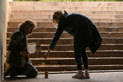 Woman giving money to poor ...