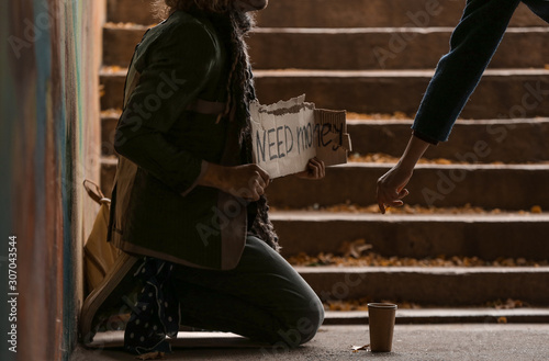 Woman giving money to poor ...