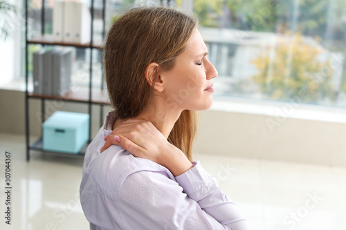 Free Download Young businesswoman suffering from back pain in office - GFXLoad