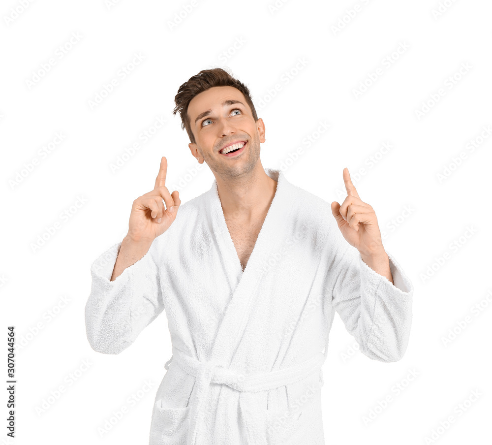 Handsome man in bathrobe pointing at something on white background Handsome man in bathrobe pointing at something on white background