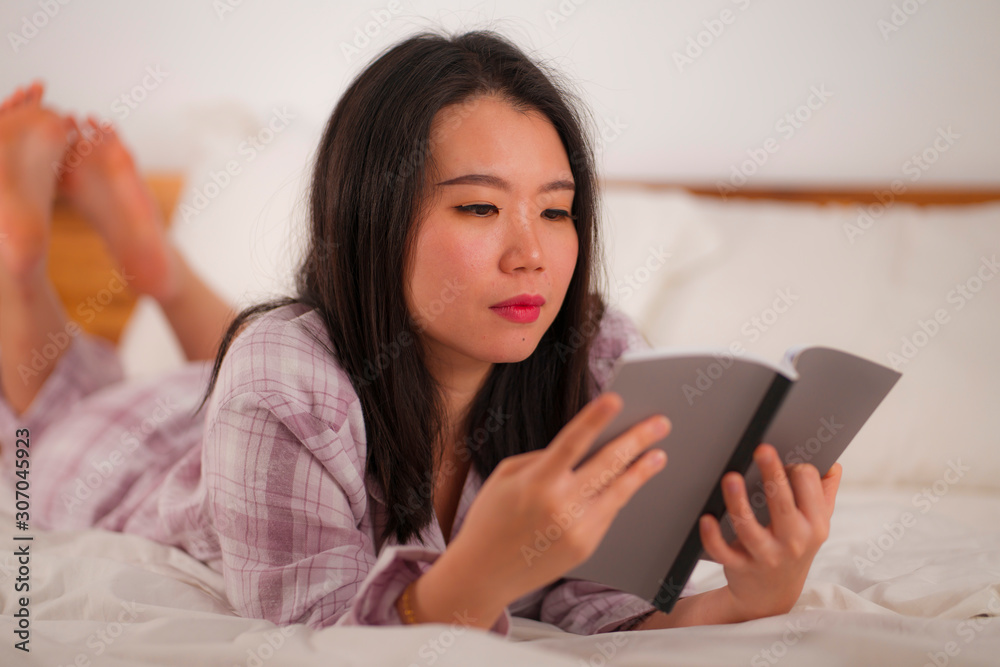 young beautiful and sweet Asian Korean woman in bed reading book novel feeling happy and playful or studying at home wearing cute pajamas looking cozy and homey young beautiful and sweet Asian Korean woman in bed reading book novel feeling happy and playful or studying at home wearing cute pajamas looking cozy and homey