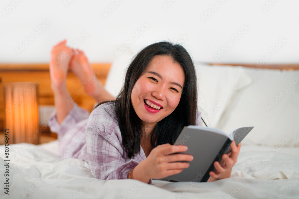 young beautiful and sweet Asian Chinese woman in bed reading book novel feeling happy and playful or studying at home wearing cute pajamas looking cozy and homey young beautiful and sweet Asian Chinese woman in bed reading book novel feeling happy and playful or studying at home wearing cute pajamas looking cozy and homey