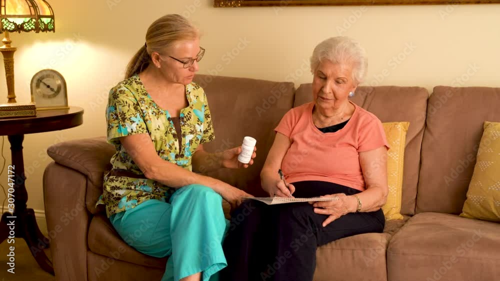 Home healthcare nurse going over medications with elderly woman while sitting in living room. Home healthcare nurse going over medications with elderly woman while sitting in living room.