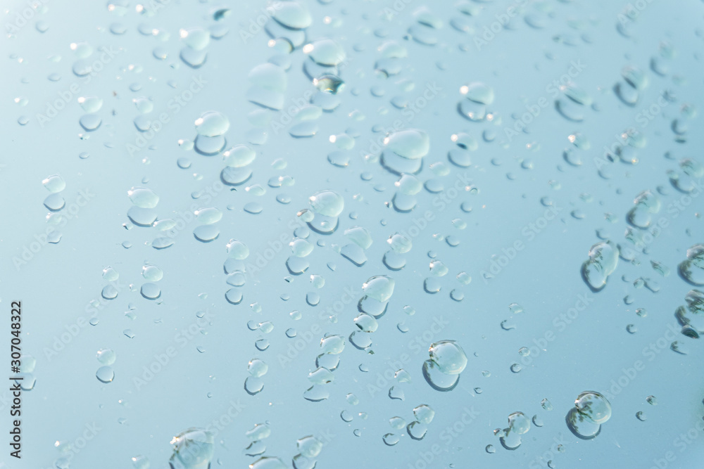 Raindrop water dew drop on glass wet white gray blue background.