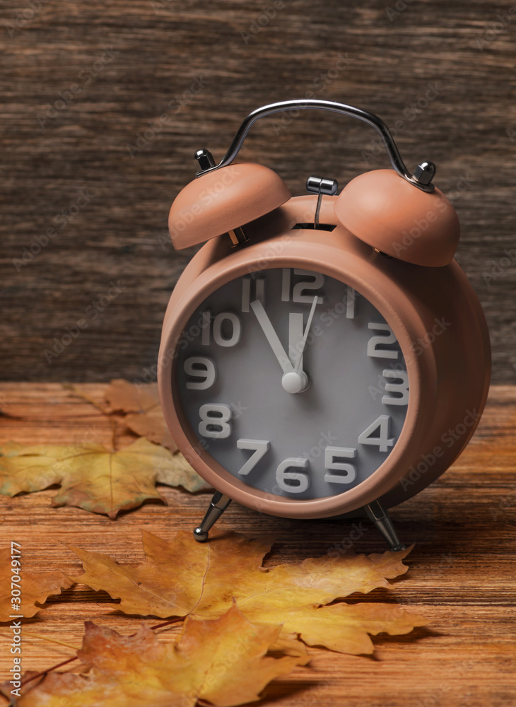 clock on old wooden background decorated with autumn leaves clock on old wooden background decorated with autumn leaves