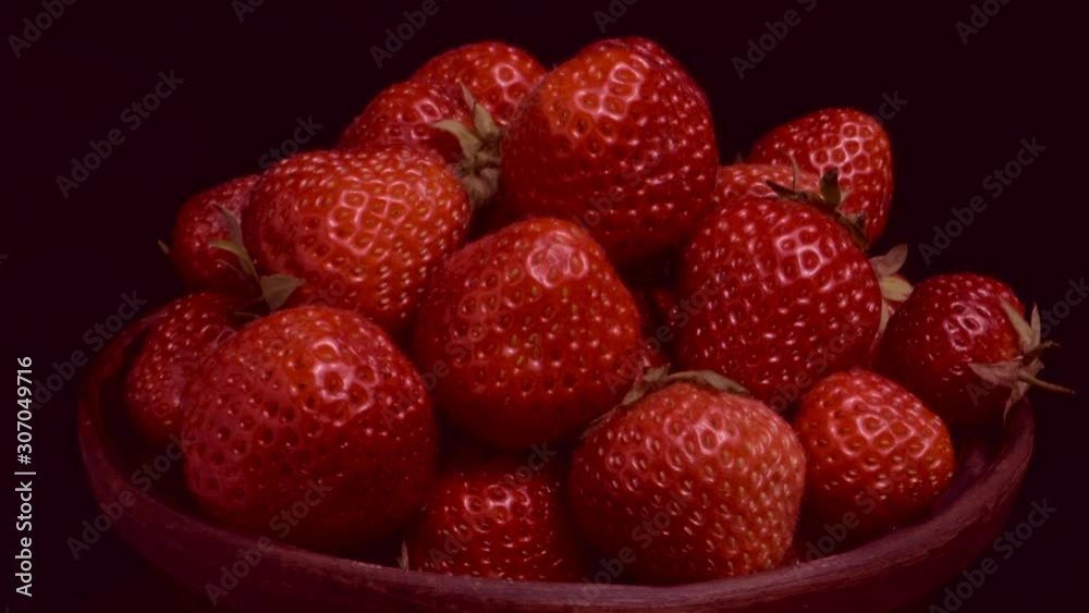 Rotation of fresh strawberries in ceramic dishes on black background. Rotation 360 degrees, closeup. 4K - 50fps Rotation of fresh strawberries in ceramic dishes on black background. Rotation 360 degrees, closeup. 4K - 50fps