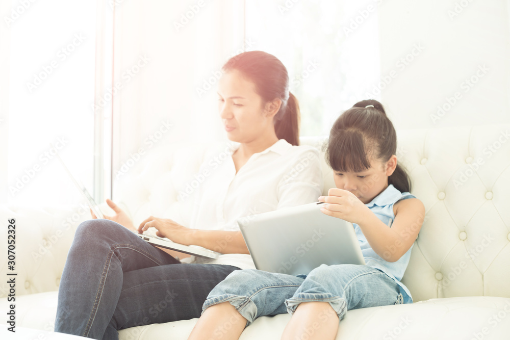 mother with daughter looking at Laptop on sofa mother with daughter looking at Laptop on sofa