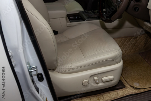 Clean after washing the front passenger seats of matte beige genuine leather inside the interior of an expensive suv, preparation before selling the car. Auto service industry. detailing cleaning. © Aleksandr Kondratov