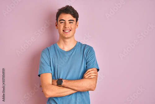 Slika na platnu Teenager boy wearing casual t-shirt standing over blue isolated background happy face smiling with crossed arms looking at the camera