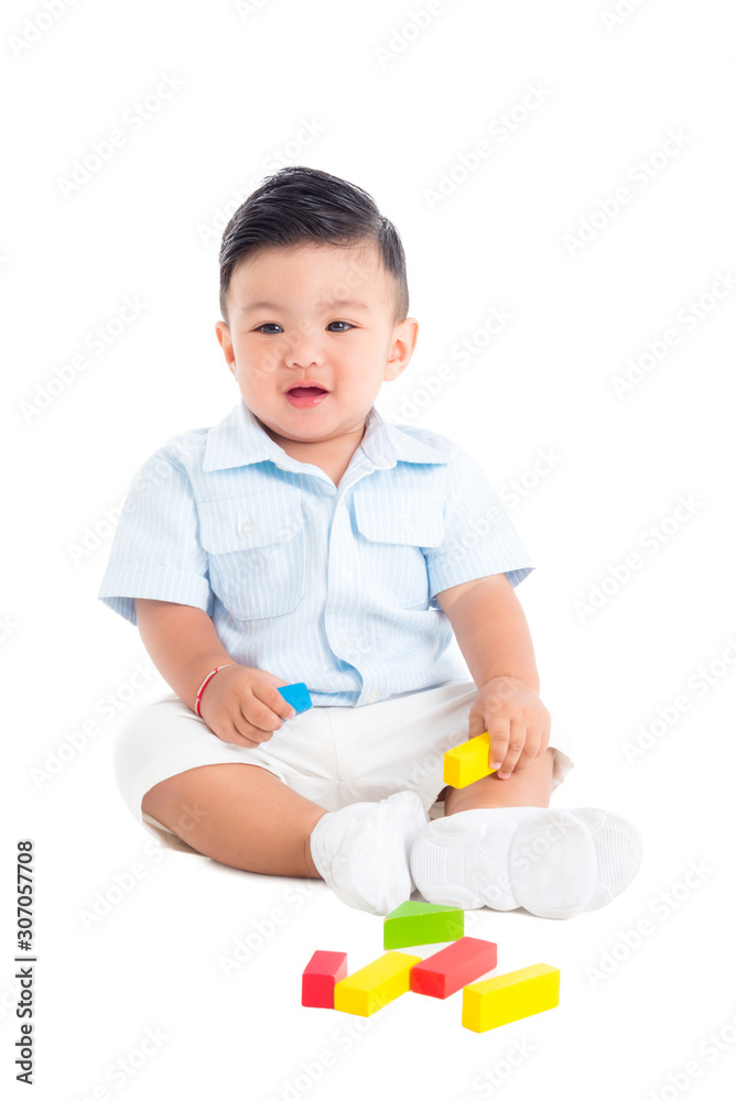 Little asian male toddler sitting on the floor and playing wood blocks over white background Little asian male toddler sitting on the floor and playing wood blocks over white background