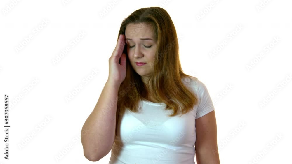 A woman touching her temple because of a heaving headache. A woman touching her temple because of a heaving headache.