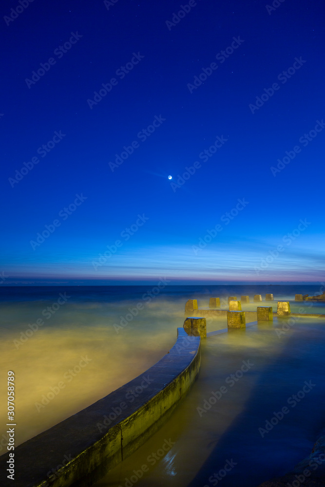 Sydney coogee beach sea pool predawn with a crescent moon portrait orientation