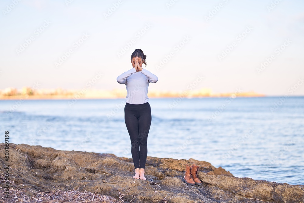 Young beautiful sportwoman practicing yoga. Coach teaching postures at the beach