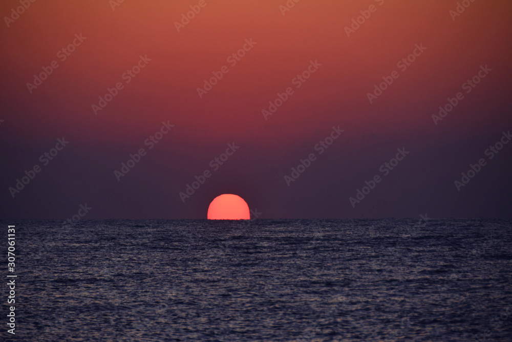 the sun rising from the sea at sunrise the sun rising from the sea at sunrise
