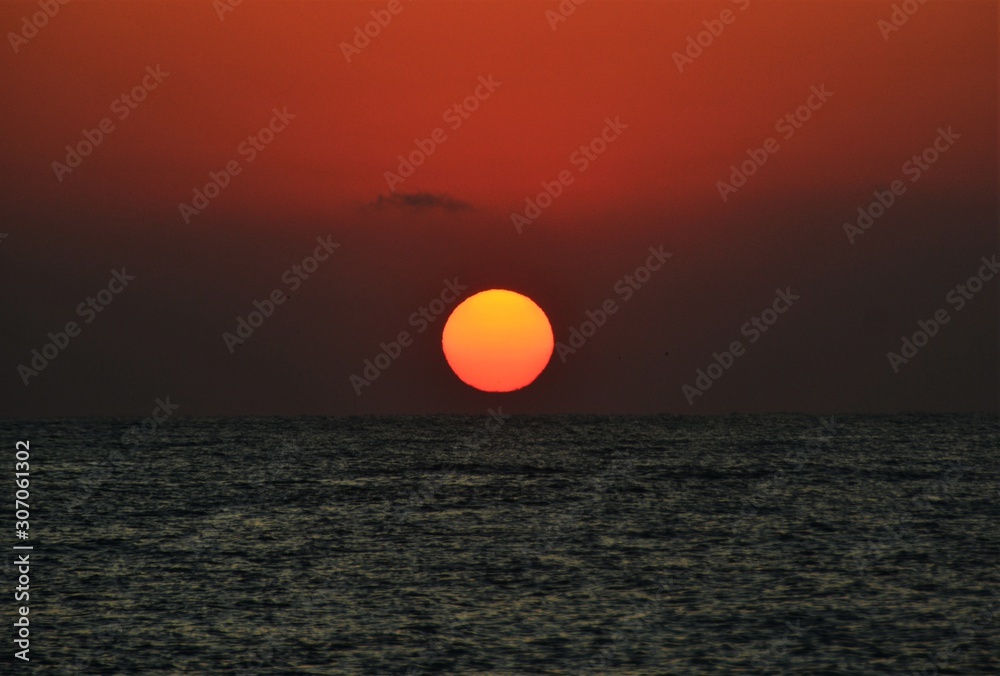 the sun like a ball rising from the sea