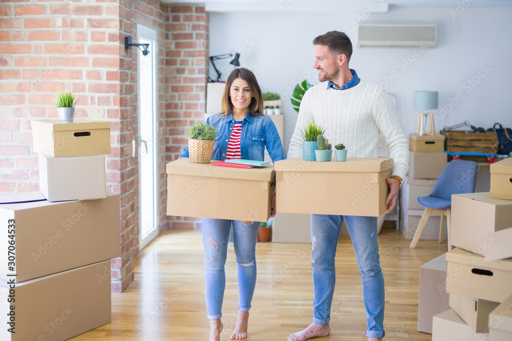 Young beautiful couple moving cardboard boxes at new home Young beautiful couple moving cardboard boxes at new home