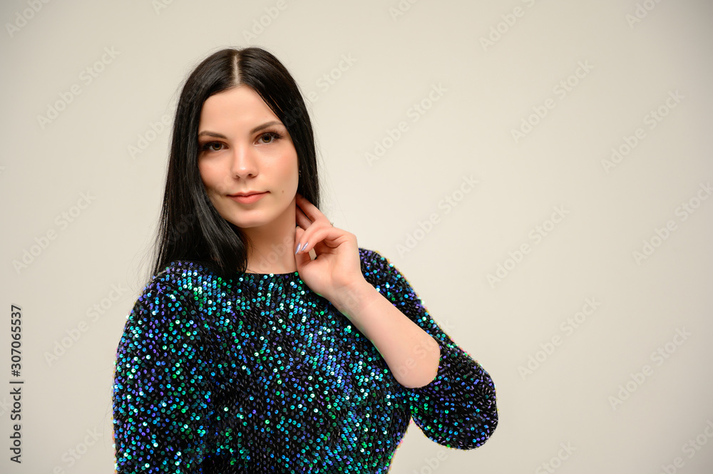 The concept of a glamorous beautiful photo model on a white background. Photo close-up portrait of a pretty brunette with great makeup and a shiny dress. The concept of a glamorous beautiful photo model on a white background. Photo close-up portrait of a pretty brunette with great makeup and a shiny dress.