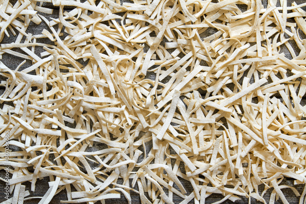 Handmade noodles are dried on a wooden board. Top view Handmade noodles are dried on a wooden board. Top view