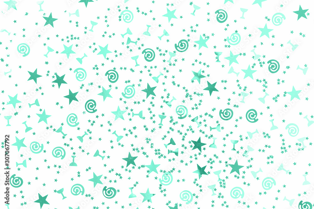 Green stars and flutes and swirls glitter and assorted sparkling confetti partially blurred isolated on white background. Festive holiday pastel backdrop flat lay isolated Green stars and flutes and swirls glitter and assorted sparkling confetti partially blurred isolated on white background. Festive holiday pastel backdrop flat lay isolated
