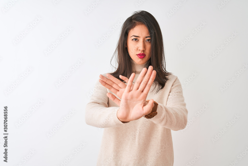 Beautiful chinese woman wearing turtleneck sweater standing over isolated white background Rejection expression crossing arms and palms doing negative sign, angry face Beautiful chinese woman wearing turtleneck sweater standing over isolated white background Rejection expression crossing arms and palms doing negative sign, angry face