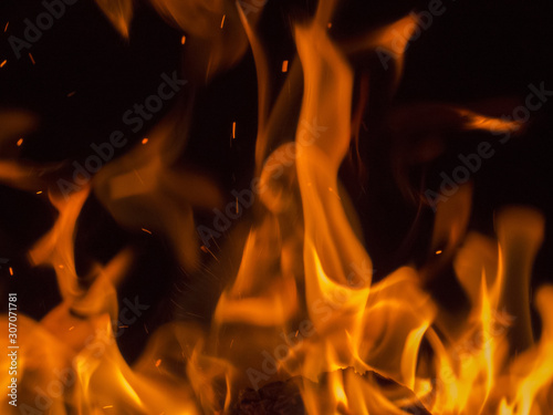 Primal bewitching magic of fire. Dance of orange flames on charred logs. Bonfire burning with crackling.